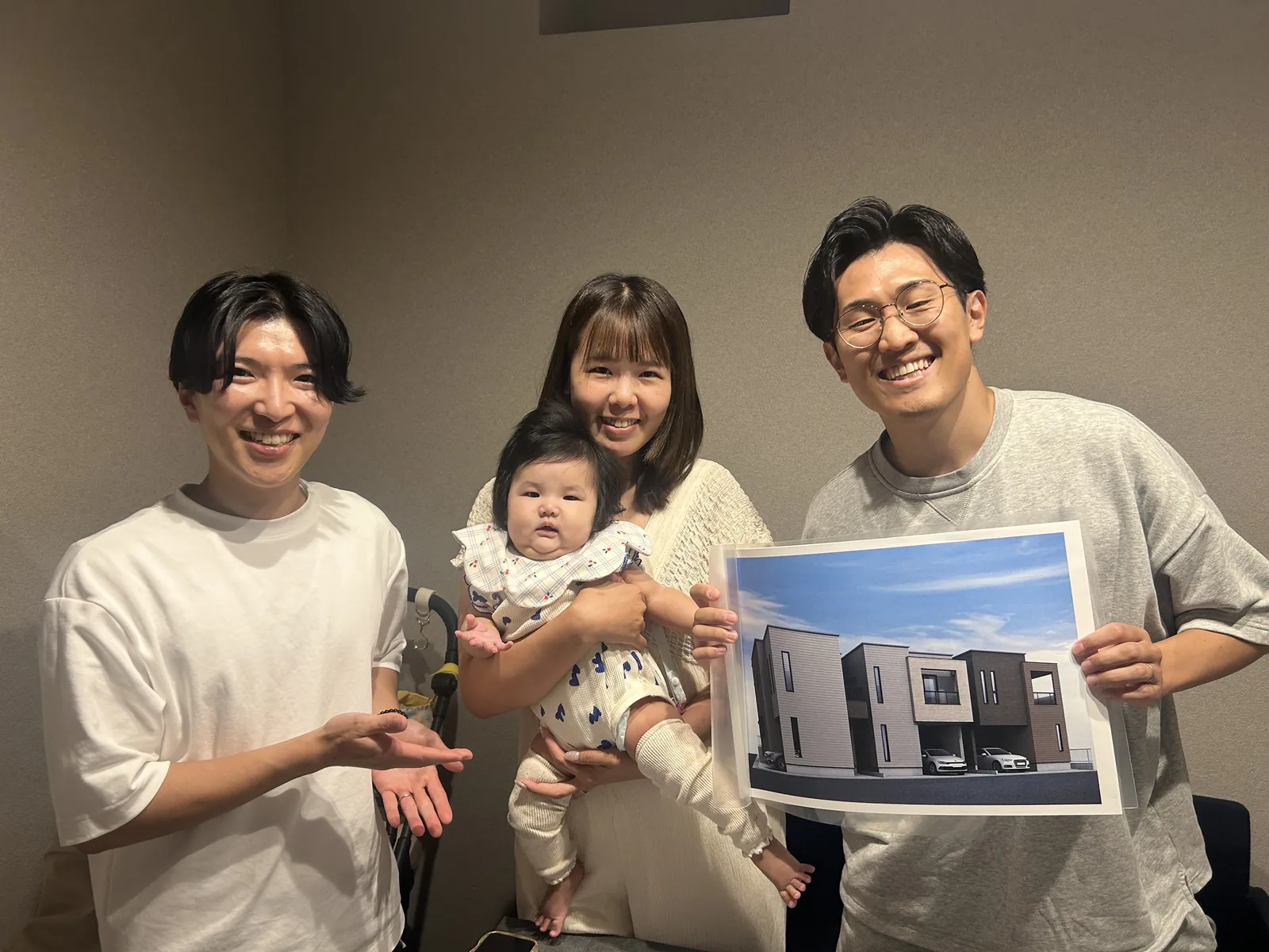 新居の完成イメージを手にするF.F様ご家族と担当者